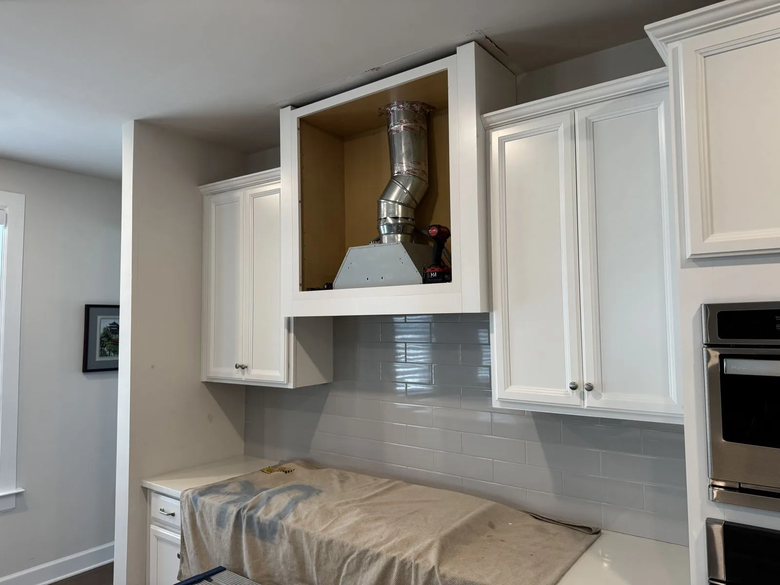 Range hood unit placed inside custom plywood soffit box during installation — West Chester kitchen